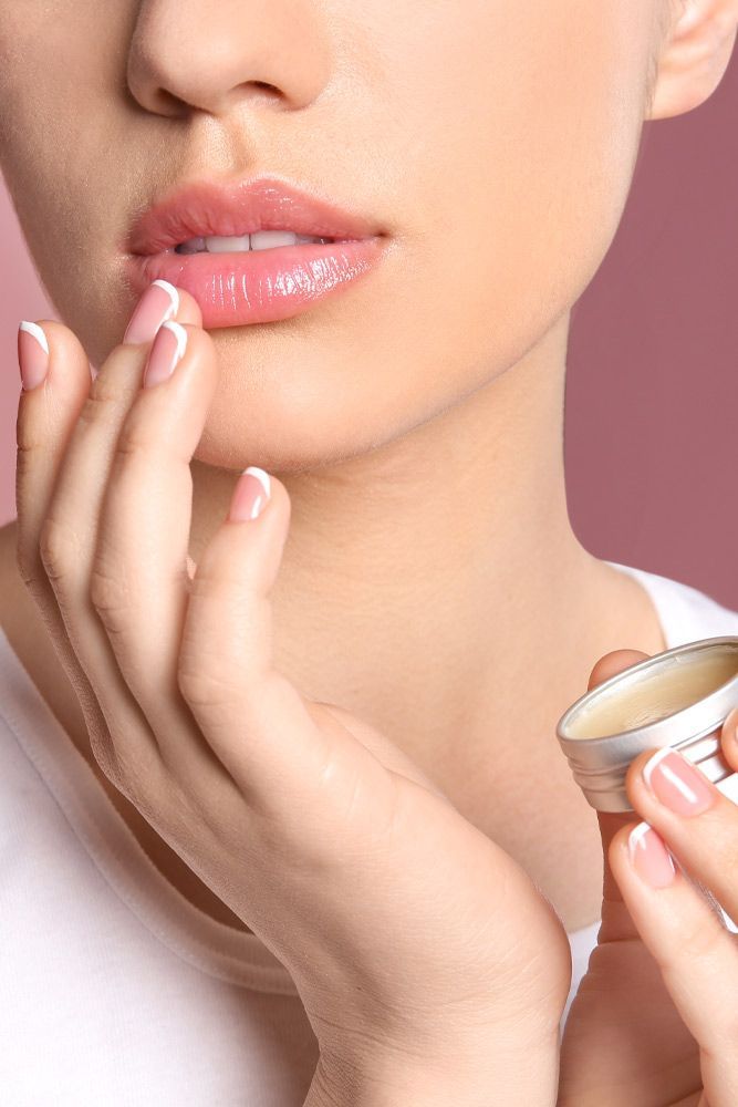 Woman applying lip balm for soft and healthy lips